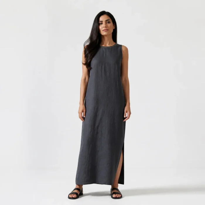 Woman in a charcoal linen column maxi dress with a gold-stitched neckline